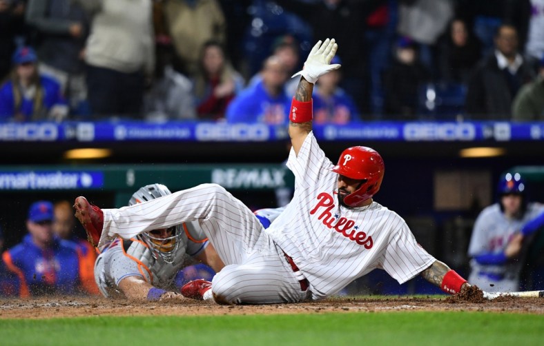 Apr 11, 2022; Philadelphia, Pennsylvania, USA; Philadelphia Phillies outfielder Kyle Schwarber (12) slides past New York Mets catcher James McCann (33) to score in the eighth inning at Citizens Bank Park. Mandatory Credit: Kyle Ross-USA TODAY Sports