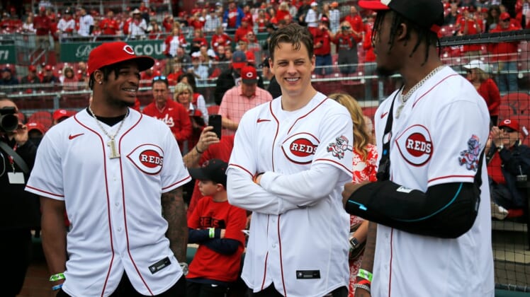 Cincinnati Bengals quarterback Joe Burrow (center) talks with wide receivers Ja'Marr Chase (left) Tee Higgins (right) before the Reds home opening game between the Cincinnati Reds and the Cleveland Guardians at Great American Ball Park in downtown Cincinnati on Tuesday, April 12, 2022.Cleveland Guardians At Cincinnati Reds Home Opener