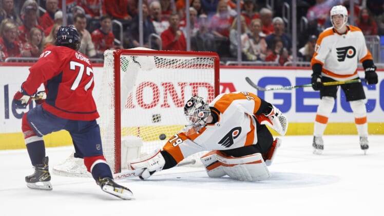 Apr 12, 2022; Washington, District of Columbia, USA;  Washington Capitals right wing T.J. Oshie (77) scores a goal on Philadelphia Flyers goaltender Carter Hart (79) in the first period at Capital One Arena. Mandatory Credit: Geoff Burke-USA TODAY Sports