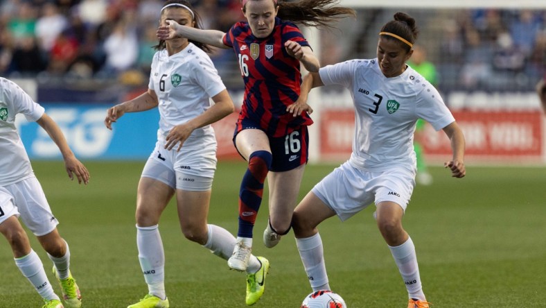 Apr 12, 2022; Chester, Pennsylvania, USA; United States midfielder Rose Lavelle (16) leaps over the defense of Uzbekistan defender Kuchkarova Ugiloy (3) during the first half of an international friendly women's soccer match at Subaru Park. Mandatory Credit: Bill Streicher-USA TODAY Sports