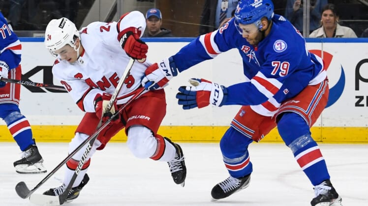 Apr 12, 2022; New York, New York, USA;  Carolina Hurricanes center Seth Jarvis (24) skates with the puck defended by New York Rangers defenseman K'Andre Miller (79) during the second period at Madison Square Garden. Mandatory Credit: Dennis Schneidler-USA TODAY Sports