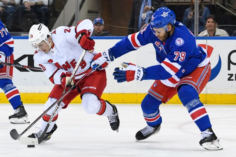 Apr 12, 2022; New York, New York, USA;  Carolina Hurricanes center Seth Jarvis (24) skates with the puck defended by New York Rangers defenseman K'Andre Miller (79) during the second period at Madison Square Garden. Mandatory Credit: Dennis Schneidler-USA TODAY Sports
