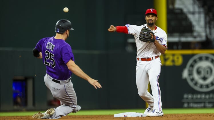Apr 12, 2022; Arlington, Texas, USA;  Texas Rangers second baseman Marcus Semien (2) throws past Colorado Rockies first baseman C.J. Cron (25) to complete a double play during the third inning at Globe Life Field. Mandatory Credit: Kevin Jairaj-USA TODAY Sports