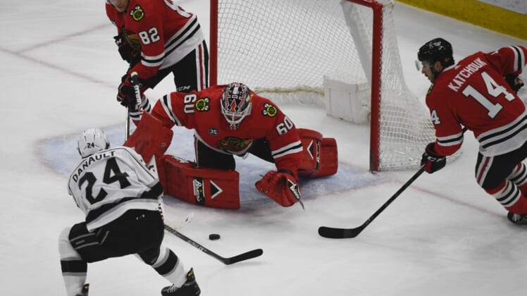 Apr 12, 2022; Chicago, Illinois, USA;  Chicago Blackhawks goaltender Collin Delia (60) defends against Los Angeles Kings center Phillip Danault (24) during the first period at the United Center. Mandatory Credit: Matt Marton-USA TODAY Sports