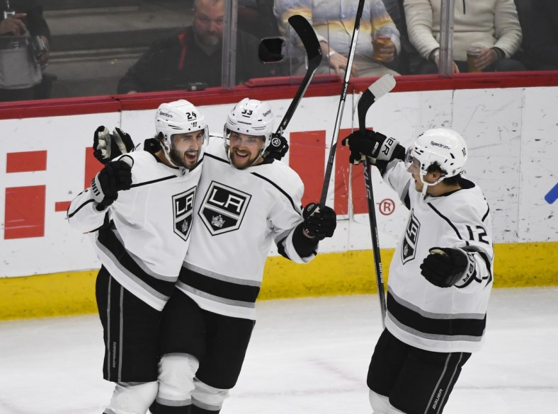 Apr 12, 2022; Chicago, Illinois, USA;  Los Angeles Kings center Phillip Danault (24) celebrates his goal with left wing Viktor Arvidsson (33) and center Trevor Moore (12) against the Chicago Blackhawks during the first period at the United Center. Mandatory Credit: Matt Marton-USA TODAY Sports