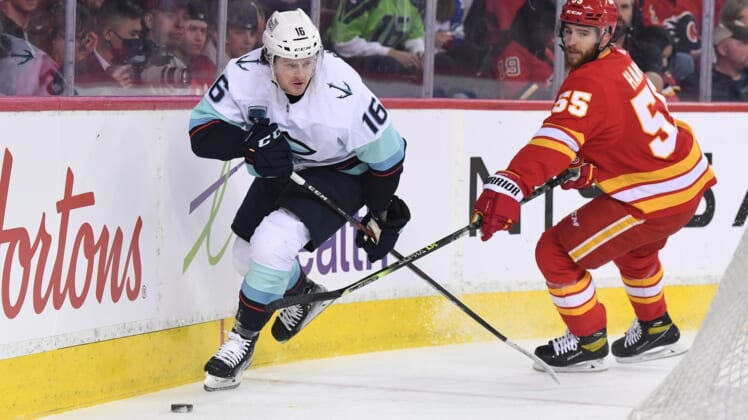 Apr 12, 2022; Calgary, Alberta, CAN; Seattle Kraken forward Jared McCann (16) and Calgary Flames defenseman Noah Hanifin (55) battle for the puck in the first period at Scotiabank Saddledome. Mandatory Credit: Candice Ward-USA TODAY Sports