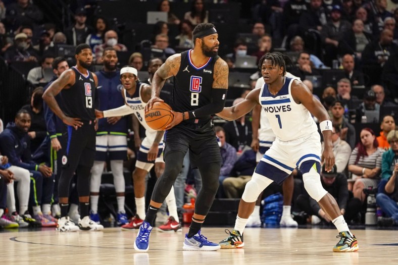Apr 12, 2022; Minneapolis, Minnesota, USA;  Los Angeles Clippers forward Marcus Morris (8) controls the ball as Minnesota Timberwolves guard Anthony Edwards (1) defends during the first quarter of a play-in game at Target Center. Mandatory Credit: Nick Wosika-USA TODAY Sports