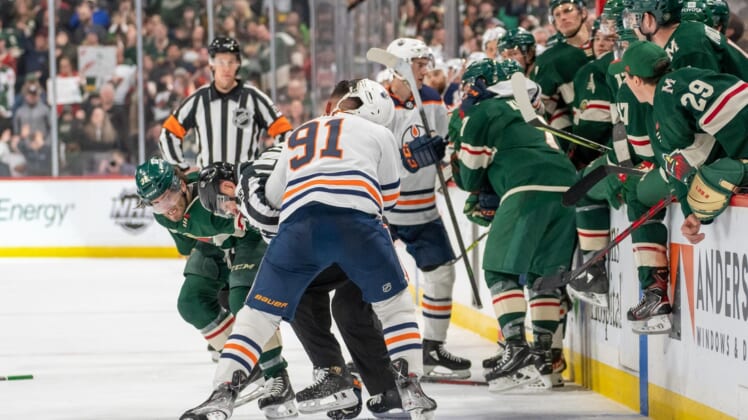 Apr 12, 2022; Saint Paul, Minnesota, USA; Minnesota Wild right wing Ryan Hartman (38) and Edmonton Oilers left wing Evander Kane (91) fight in front of the benches in the third period at Xcel Energy Center. Mandatory Credit: Matt Blewett-USA TODAY Sports