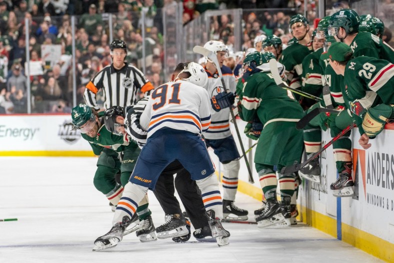 Apr 12, 2022; Saint Paul, Minnesota, USA; Minnesota Wild right wing Ryan Hartman (38) and Edmonton Oilers left wing Evander Kane (91) fight in front of the benches in the third period at Xcel Energy Center. Mandatory Credit: Matt Blewett-USA TODAY Sports