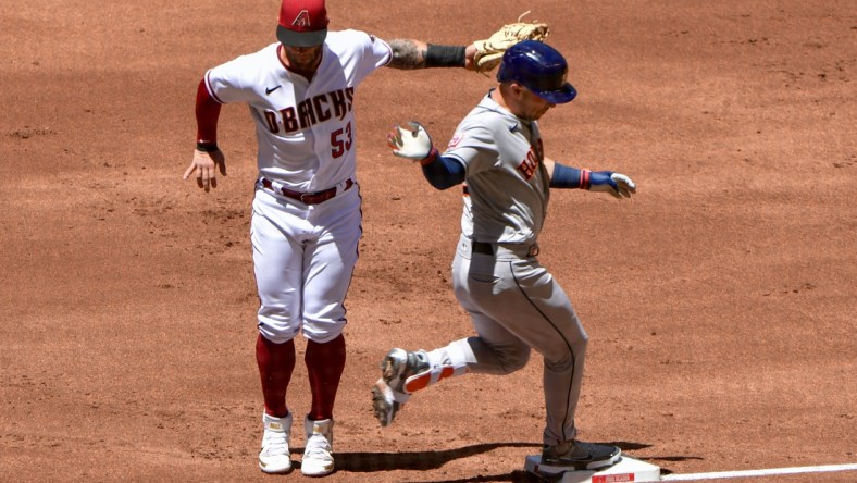 Apr 13, 2022; Phoenix, Arizona, USA; Houston Astros third baseman Alex Bregman (2) is tagged by Arizona Diamondbacks first baseman Christian Walker (53) in the first inning at Chase Field. Mandatory Credit: Matt Kartozian-USA TODAY Sports