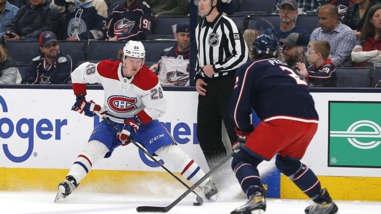 Apr 13, 2022; Columbus, Ohio, USA; Montreal Canadiens center Christian Dvorak (28) passes the puck as Columbus Blue Jackets defenseman Andrew Peeke (2) defends during the first period at Nationwide Arena. Mandatory Credit: Russell LaBounty-USA TODAY Sports