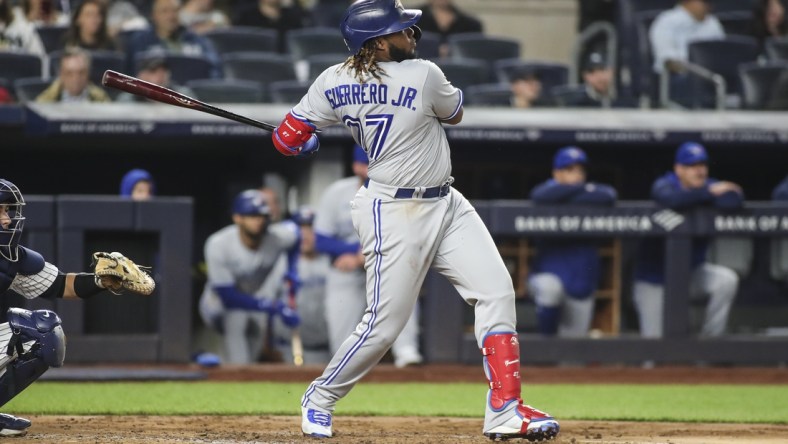 Apr 13, 2022; Bronx, New York, USA;  Toronto Blue Jays first baseman Vladimir Guerrero Jr. (27) hits a two run home run in the third inning against the New York Yankees at Yankee Stadium. Mandatory Credit: Wendell Cruz-USA TODAY Sports