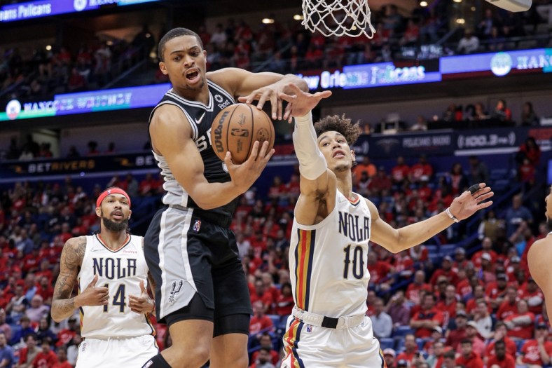Apr 13, 2022; New Orleans, Louisiana, USA; San Antonio Spurs forward Keldon Johnson (3) grabs a rebound against New Orleans Pelicans center Jaxson Hayes (10) during the first half of a play-in playoff game at the Smoothie King Center. Mandatory Credit: Stephen Lew-USA TODAY Sports