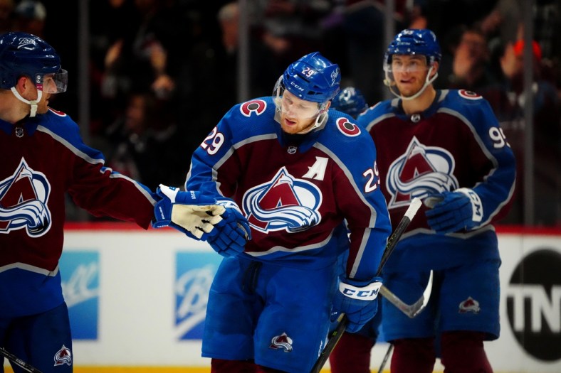 Apr 13, 2022; Denver, Colorado, USA; Colorado Avalanche center Nathan MacKinnon (29) celebrates a hat trick goal with defenseman Devon Toews (7) in the third period against the Los Angeles Kings at Ball Arena. Mandatory Credit: Ron Chenoy-USA TODAY Sports