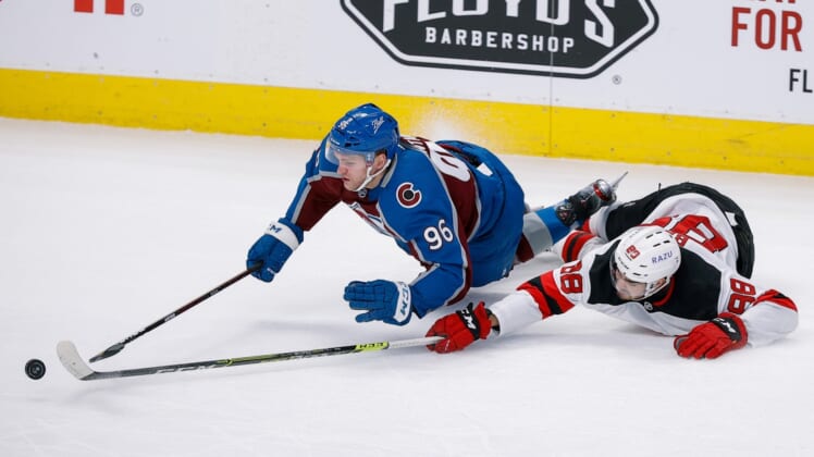 Apr 14, 2022; Denver, Colorado, USA; Colorado Avalanche right wing Mikko Rantanen (96) gets tripped up by New Jersey Devils defenseman Kevin Bahl (88) in the first period at Ball Arena. Mandatory Credit: Isaiah J. Downing-USA TODAY Sports