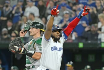 Apr 15, 2022; Toronto, Ontario, CAN;   Toronto Blue Jays designated hitter Vladimir Guerrero Jr. (27) celebrates after hitting a home run as Oakland Athletics catcher Sean Murphy (12) adjusts his mask in the first inning at Rogers Centre. Mandatory Credit: Dan Hamilton-USA TODAY Sports