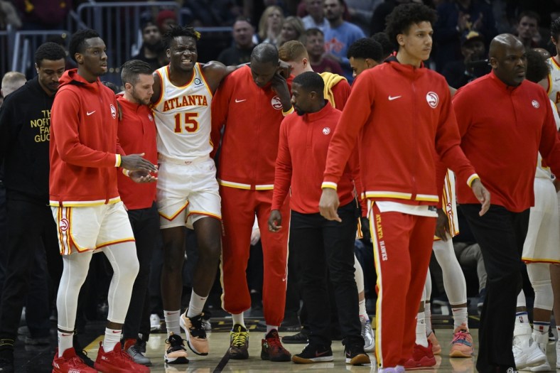 Apr 15, 2022; Cleveland, Ohio, USA; Atlanta Hawks center Clint Capela (15) is helped off the court in the second quarter against the Cleveland Cavaliers at Rocket Mortgage FieldHouse. Mandatory Credit: David Richard-USA TODAY Sports