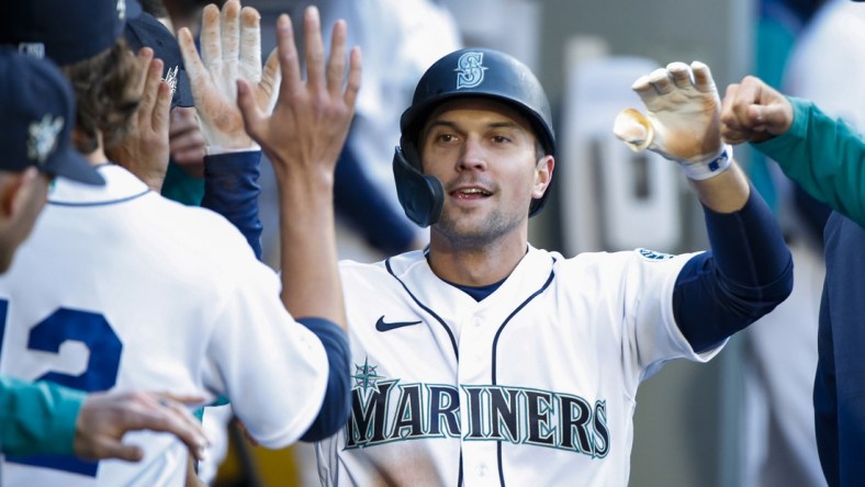 Apr 15, 2022; Seattle, Washington, USA; Seattle Mariners second baseman Adam Frazier (42) is greeted by teammates in the dugout after scoring a run against the Houston Astros during the first inning at T-Mobile Park. Mandatory Credit: Joe Nicholson-USA TODAY Sports