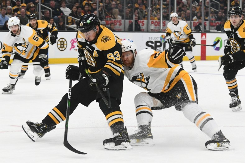 Apr 16, 2022; Boston, Massachusetts, USA; Boston Bruins left wing Brad Marchand (63) draws a holding penalty from Pittsburgh Penguins defenseman Mike Matheson (5) during the first period at TD Garden. Mandatory Credit: Brian Fluharty-USA TODAY Sports