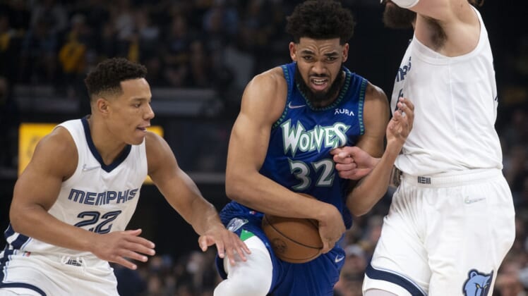 Apr 16, 2022; Memphis, Tennessee, USA; Minnesota Timberwolves center Karl-Anthony Towns (32) keeps control of the ball as he   s guarded by Memphis Grizzlies guard Desmond Bane (22) and Memphis Grizzlies center Steven Adams (4) during the first half of game one of the first round for the 2022 NBA playoffs at FedExForum. Mandatory Credit: Christine Tannous-USA TODAY Sports