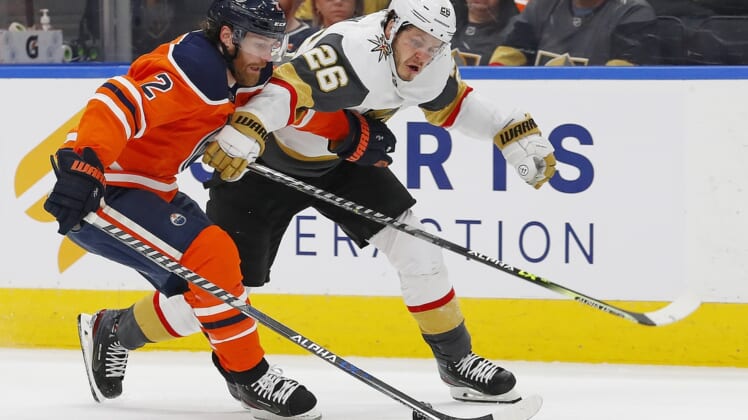 Apr 16, 2022; Edmonton, Alberta, CAN; Edmonton Oilers defensemen Duncan Keith (2) and Vegas Golden Knights forward Mattias Janmark (26) battle for a loose puck during the second period  at Rogers Place. Mandatory Credit: Perry Nelson-USA TODAY Sports