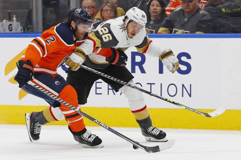 Apr 16, 2022; Edmonton, Alberta, CAN; Edmonton Oilers defensemen Duncan Keith (2) and Vegas Golden Knights forward Mattias Janmark (26) battle for a loose puck during the second period  at Rogers Place. Mandatory Credit: Perry Nelson-USA TODAY Sports