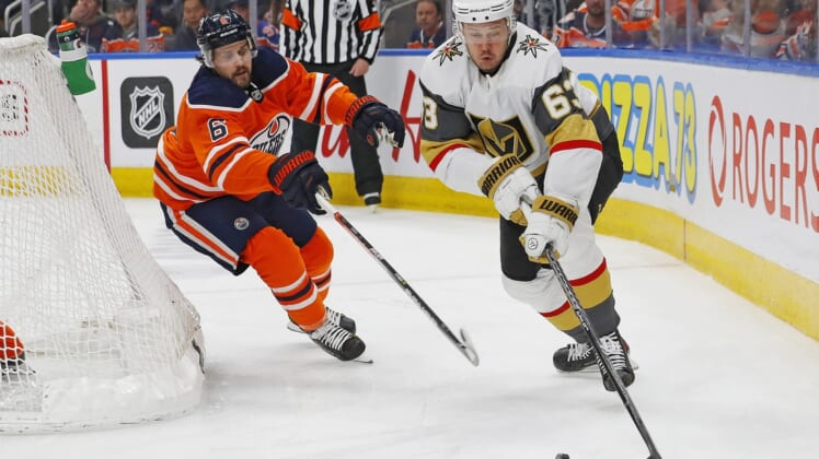 Apr 16, 2022; Edmonton, Alberta, CAN; Vegas Golden Knights forward Evgenii Dadonov (63) looks to make a pass in front of Edmonton Oilers defensemen Kris Russell (6) during the second period at Rogers Place. Mandatory Credit: Perry Nelson-USA TODAY Sports