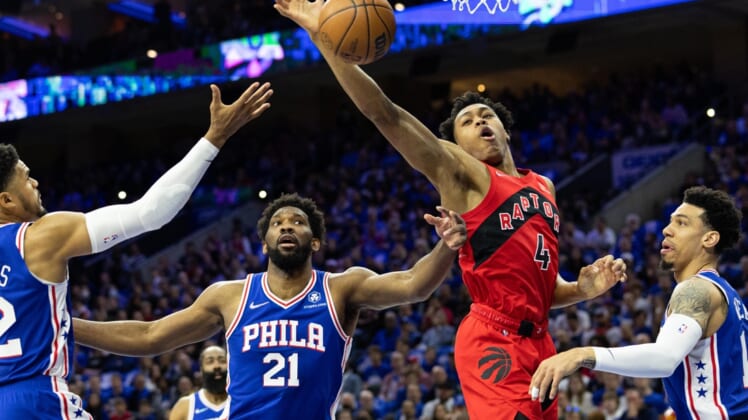 Apr 16, 2022; Philadelphia, Pennsylvania, USA; Toronto Raptors forward Scottie Barnes (4) reaches for a rebound in front of Philadelphia 76ers center Joel Embiid (21) during the first quarter of game one of the first round for the 2022 NBA playoffs at Wells Fargo Center. Mandatory Credit: Bill Streicher-USA TODAY Sports