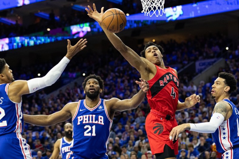 Apr 16, 2022; Philadelphia, Pennsylvania, USA; Toronto Raptors forward Scottie Barnes (4) reaches for a rebound in front of Philadelphia 76ers center Joel Embiid (21) during the first quarter of game one of the first round for the 2022 NBA playoffs at Wells Fargo Center. Mandatory Credit: Bill Streicher-USA TODAY Sports