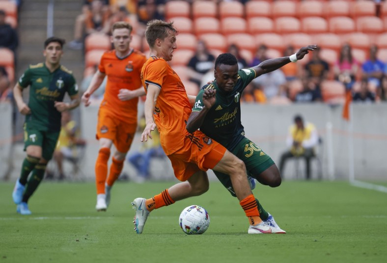 Apr 16, 2022; Houston, Texas, USA; Portland Timbers midfielder Santiago Moreno (30) attempts to get around Houston Dynamo FC midfielder Griffin Dorsey (25) during the first half at PNC Stadium. Mandatory Credit: Troy Taormina-USA TODAY Sports