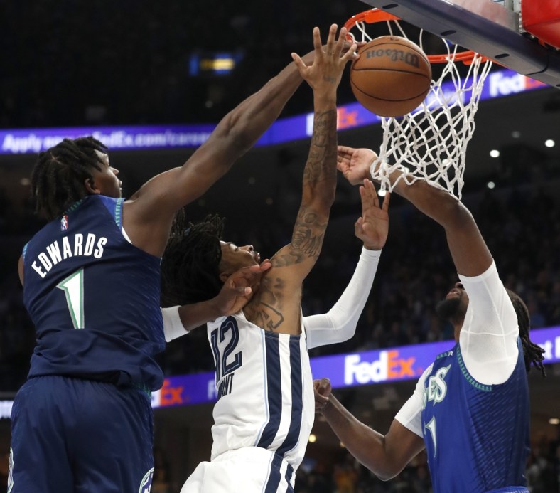 Apr 16, 2022; Memphis, Tennessee, USA; Memphis Grizzlies guard Ja Morant (12) shoots the ball as he is guarded by Minnesota Timberwolves forward Anthony Edwards (1) and Minnesota Timberwolves center Naz Reid (11) during the first half of game one of the first round for the 2022 NBA playoffs at FedExForum. Mandatory Credit: Christine Tannous-USA TODAY Sports
