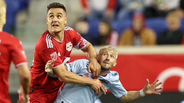 Apr 16, 2022; Harrison, New Jersey, USA; New York Red Bulls midfielder Aaron Long (33) and FC Dallas forward Paul Arriola (7) battle for position in the second half of their game at Red Bull Arena. Mandatory Credit: Vincent Carchietta-USA TODAY Sports