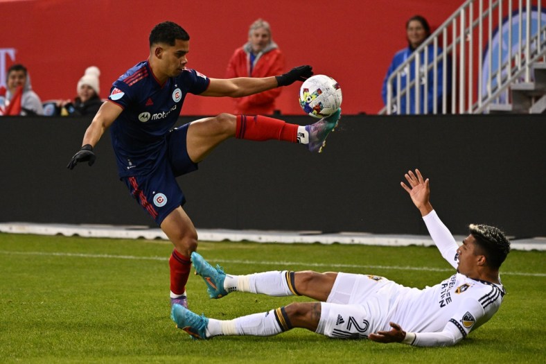 Apr 16, 2022; Chicago, Illinois, USA;  Chicago Fire FC defender Miguel   ngel Navarro (6) controls the ball over a fallen LA Galaxy defender, Julian Araujo (2), in the first half at Soldier Field. Mandatory Credit: Jamie Sabau-USA TODAY Sports