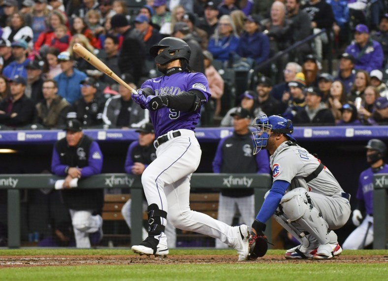 Apr 16, 2022; Denver, Colorado, USA;  Colorado Rockies first baseman Connor Joe (9) triples to center field to drive in Colorado Rockies catcher Dom Nunez (3) during the third inning against the Chicago Cubs at Coors Field. Mandatory Credit: John Leyba-USA TODAY Sports