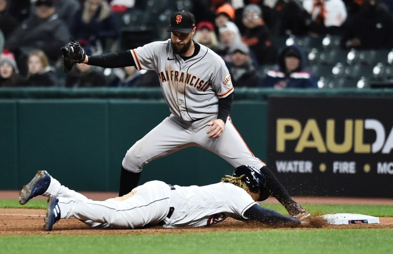 Apr 16, 2022; Cleveland, Ohio, USA; Cleveland Guardians third baseman Jose Ramirez (11) dives back to first base as San Francisco Giants first baseman Brandon Belt (9) takes the throw to force him out during the eighth inning at Progressive Field. Mandatory Credit: Ken Blaze-USA TODAY Sports