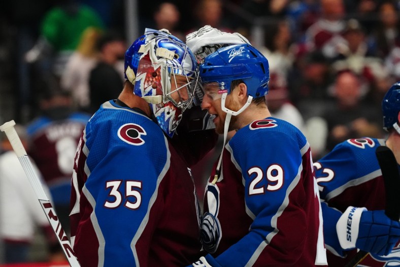 Apr 16, 2022; Denver, Colorado, USA; Colorado Avalanche goaltender Darcy Kuemper (35) and center Nathan MacKinnon (29) celebrate after defeating the Carolina Hurricanes at Ball Arena. Mandatory Credit: Ron Chenoy-USA TODAY Sports