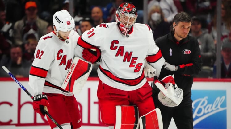 Apr 16, 2022; Denver, Colorado, USA; Carolina Hurricanes goaltender Frederik Andersen (31) is helped off the ice by center Jesperi Kotkaniemi (82) in the third period against the Colorado Avalanche at Ball Arena. Mandatory Credit: Ron Chenoy-USA TODAY Sports
