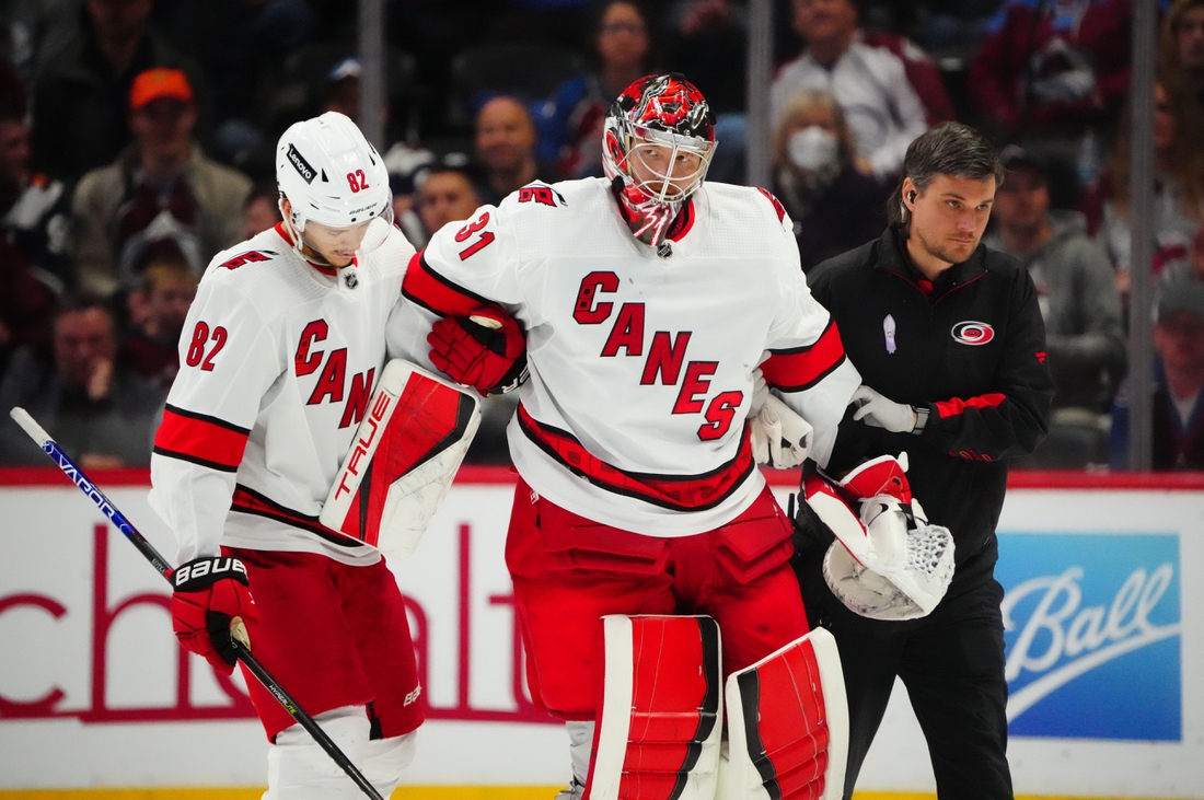 Apr 16, 2022; Denver, Colorado, USA; Carolina Hurricanes goaltender Frederik Andersen (31) is helped off the ice by center Jesperi Kotkaniemi (82) in the third period against the Colorado Avalanche at Ball Arena. Mandatory Credit: Ron Chenoy-USA TODAY Sports