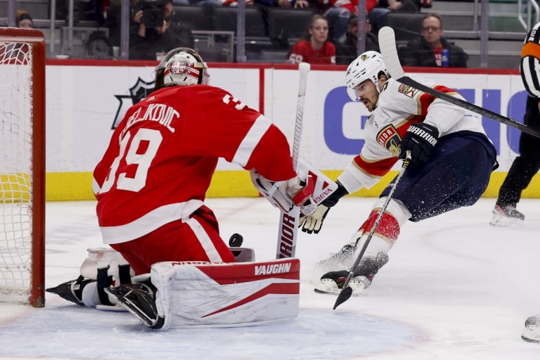 Apr 17, 2022; Detroit, Michigan, USA; Florida Panthers defenseman MacKenzie Weegar (52) skate in on Detroit Red Wings goaltender Alex Nedeljkovic (39) chased by center Joe Veleno (90) battle for the puck in the first period at Little Caesars Arena. Mandatory Credit: Rick Osentoski-USA TODAY Sports