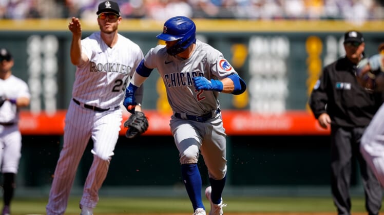Apr 17, 2022; Denver, Colorado, USA; Chicago Cubs shortstop Nico Hoerner (2) gets caught in a run down as Colorado Rockies first baseman C.J. Cron (25) throws the ball in the second inning at Coors Field. Mandatory Credit: Isaiah J. Downing-USA TODAY Sports