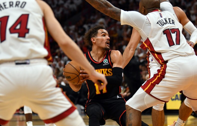 Apr 17, 2022; Miami, Florida, USA; Atlanta Hawks guard Trae Young (11) looks to pass the ball as Miami Heat forward P.J. Tucker (17) and teammate guard Tyler Herro (14) defend during the second half of game one of the first round for the 2022 NBA playoffs at FTX Arena. Mandatory Credit: Jim Rassol-USA TODAY Sports