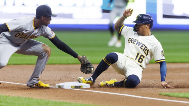 Apr 18, 2022; Milwaukee, Wisconsin, USA;  Milwaukee Brewers second baseman Kolten Wong (16) slides safely into third base before Pittsburgh Pirates third baseman Ke'Bryan Hayes (13) can apply the tag during the first inning at American Family Field. Mandatory Credit: Jeff Hanisch-USA TODAY Sports