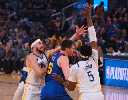 Apr 18, 2022; San Francisco, California, USA; Golden State Warriors guard Klay Thompson (11) and forward Kevon Looney (5) defend Denver Nuggets center Nikola Jokic (15) during the first quarter of game two of the first round for the 2022 NBA playoffs at Chase Center. Mandatory Credit: Kelley L Cox-USA TODAY Sports