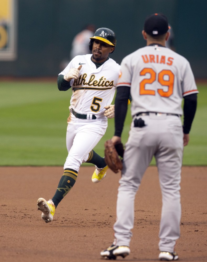 Apr 18, 2022; Oakland, California, USA; Oakland Athletics left fielder Tony Kemp (5) cruises into third base on a double by Sean Murphy during the first inning at RingCentral Coliseum. Baltimore Orioles third baseman Ramon Urias (29) watches the action. Mandatory Credit: D. Ross Cameron-USA TODAY Sports