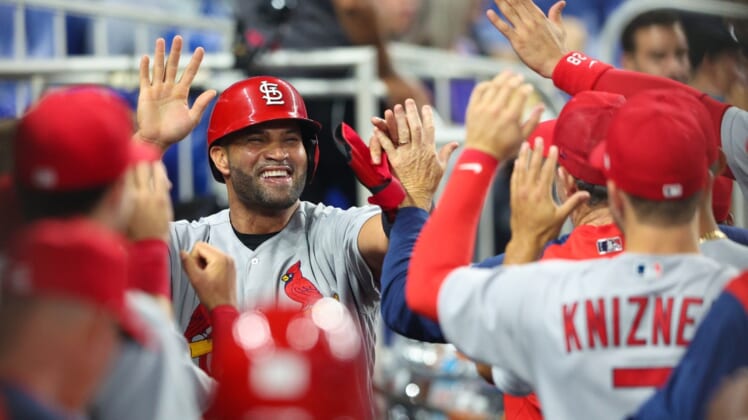 Apr 19, 2022; Miami, Florida, USA;  St. Louis Cardinals first baseman Albert Pujols (5) is congratulated after scoring a run against the Miami Marlins in the second inning at LoanDepot Park. Mandatory Credit: Nathan Ray Seebeck-USA TODAY Sports