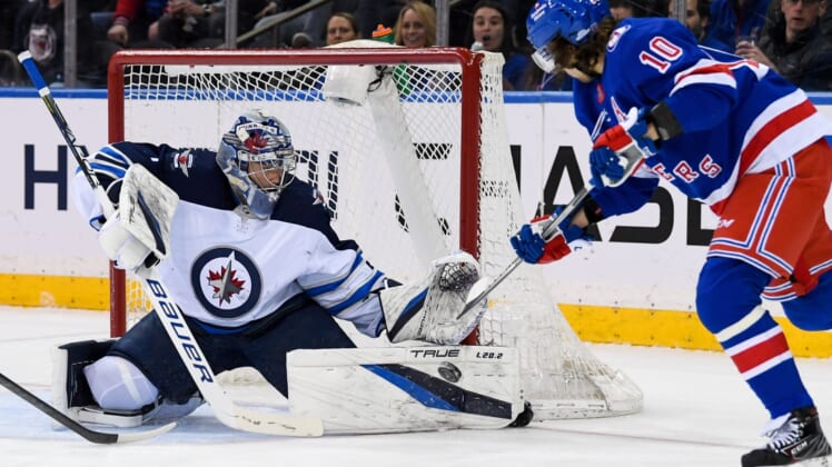 Apr 19, 2022; New York, New York, USA;  Winnipeg Jets goaltender Eric Comrie (1) makes a save on a shot from New York Rangers left wing Artemi Panarin (10) during the first period at Madison Square Garden. Mandatory Credit: Dennis Schneidler-USA TODAY Sports