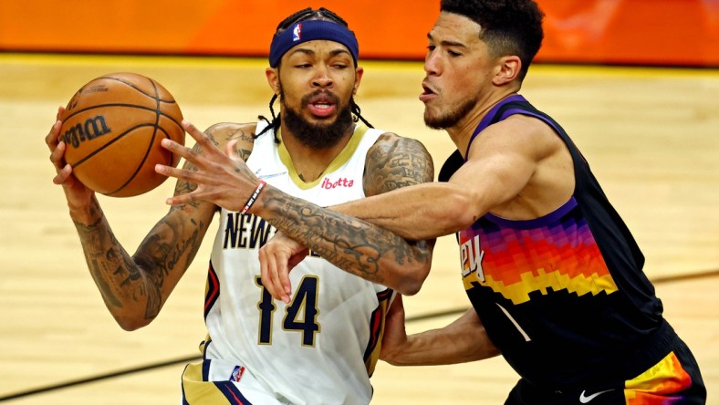 Apr 19, 2022; Phoenix, Arizona, USA; New Orleans Pelicans forward Brandon Ingram (14) drives to the basket against Phoenix Suns guard Devin Booker (1) during the first quarter during game one of the first round for the 2022 NBA playoffs at Footprint Center. Mandatory Credit: Mark J. Rebilas-USA TODAY Sports