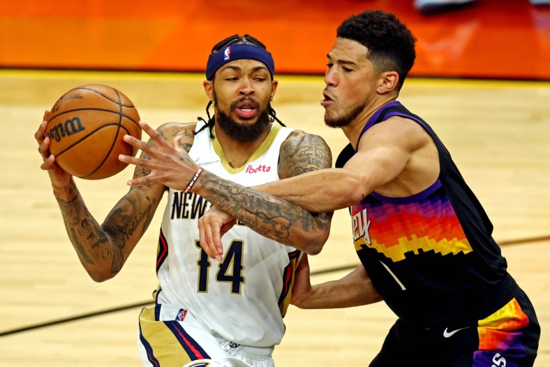 Apr 19, 2022; Phoenix, Arizona, USA; New Orleans Pelicans forward Brandon Ingram (14) drives to the basket against Phoenix Suns guard Devin Booker (1) during the first quarter during game one of the first round for the 2022 NBA playoffs at Footprint Center. Mandatory Credit: Mark J. Rebilas-USA TODAY Sports