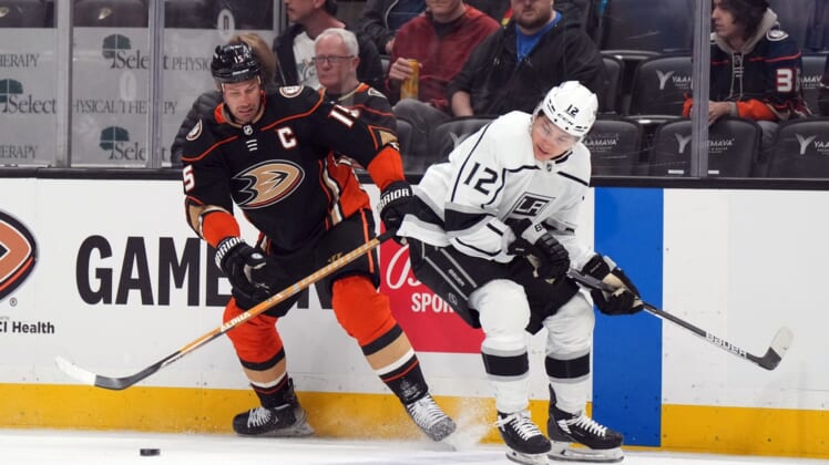 Apr 19, 2022; Anaheim, California, USA; Anaheim Ducks center Ryan Getzlaf (15) and LA Kings center Trevor Moore (12) battle for the puck in the first period at Honda Center. Mandatory Credit: Kirby Lee-USA TODAY Sports