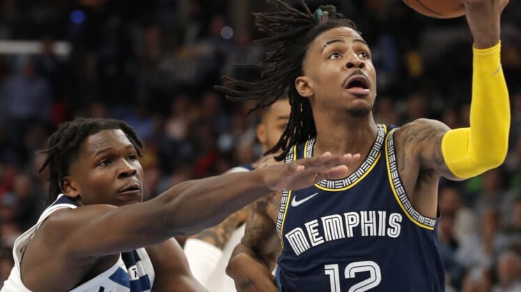 Apr 19, 2022; Memphis, Tennessee, USA; Memphis Grizzlies guard Ja Morant (12) is guarded by Minnesota Timberwolves forward Anthony Edwards (1) as he goes to shoot the ball during the second half of game two of the first round for the 2022 NBA playoffs at FedExForum. Mandatory Credit: Christine Tannous-USA TODAY Sports